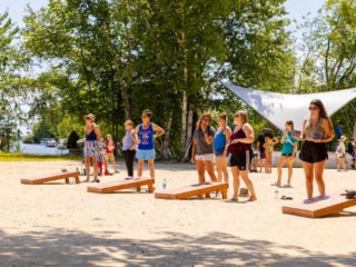 Point Sebago Resort guests enjoying cornhole acitivity on the beach