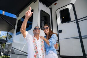 Couple with sunglasses on standing outside of their RV at Blueway RV Park in Fort Myers, Florida.