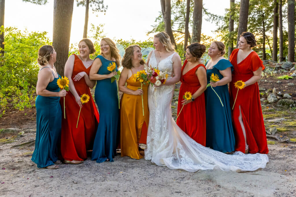 Bride surrounded by seven bridesmades at Point Sebago Resort in Maine.