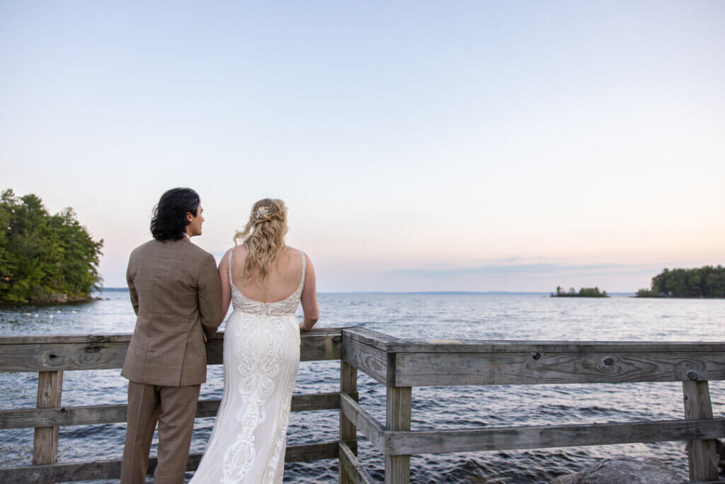 Groom and bride looking out over Sebago Lake in Maine. t Point Photo by Life in Focus.
