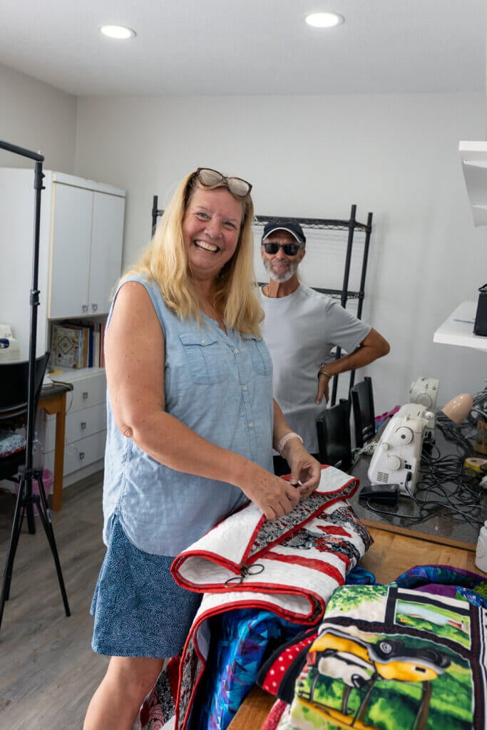 Resident holding a sewing project in the West Clubhouse sewing room