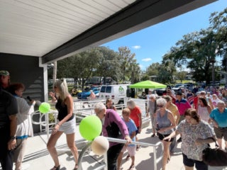 Large group of residents entering the West Clubhouse for a first look at the renovations during the reopening on October 15, 2025.