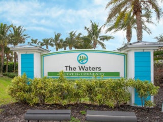 The front entrance sign for The Waters, a Cove 55+ Community in Melbourne Beach, Florida.