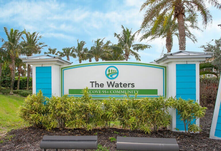 The front entrance sign for The Waters, a Cove 55+ Community in Melbourne Beach, Florida.