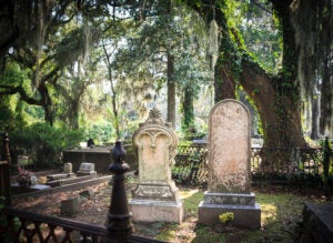 Tombstones and gravesite at Bonaventure Cemetery, Savannah, Georgia. Live Oak trees and Spanish Moss in the background.