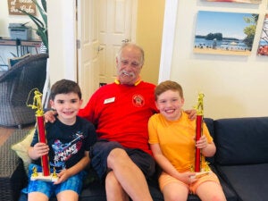 Ranger Rick posing with two boys who won trophies for Sebago Lake fishing at Point Sebago Resort in Maine.