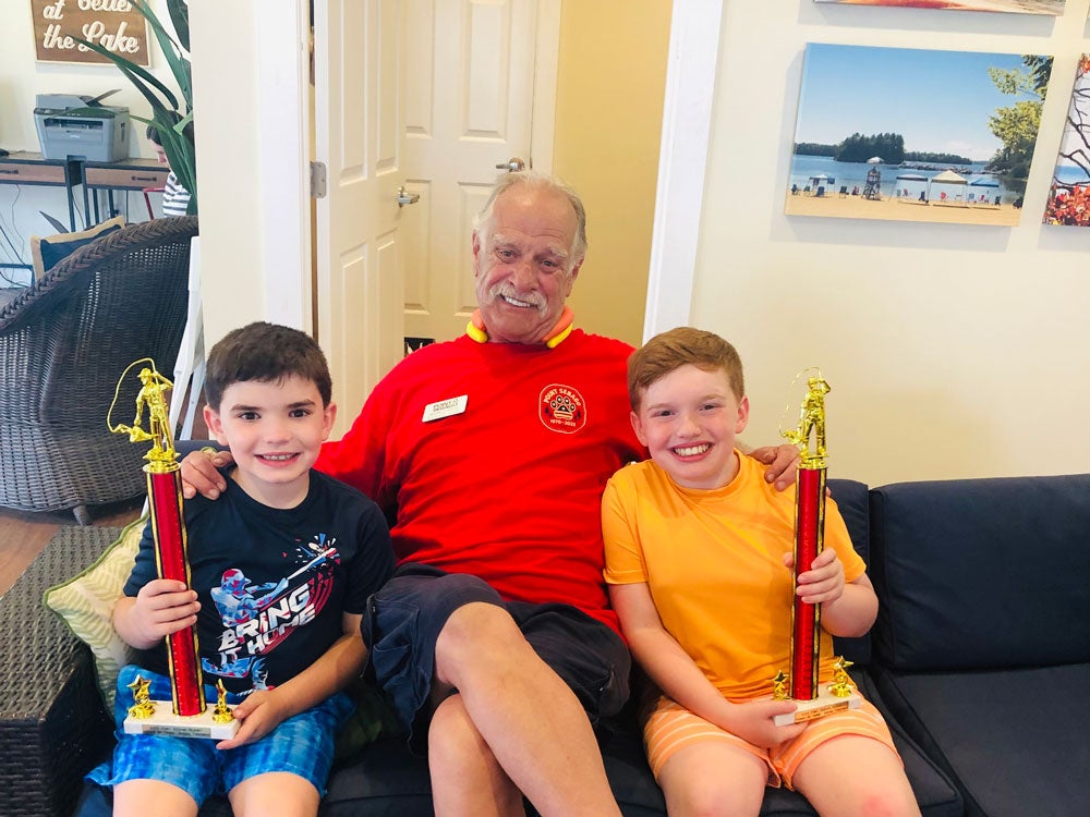 Ranger Rick posing with two boys who won trophies for Sebago Lake fishing at Point Sebago Resort in Maine.