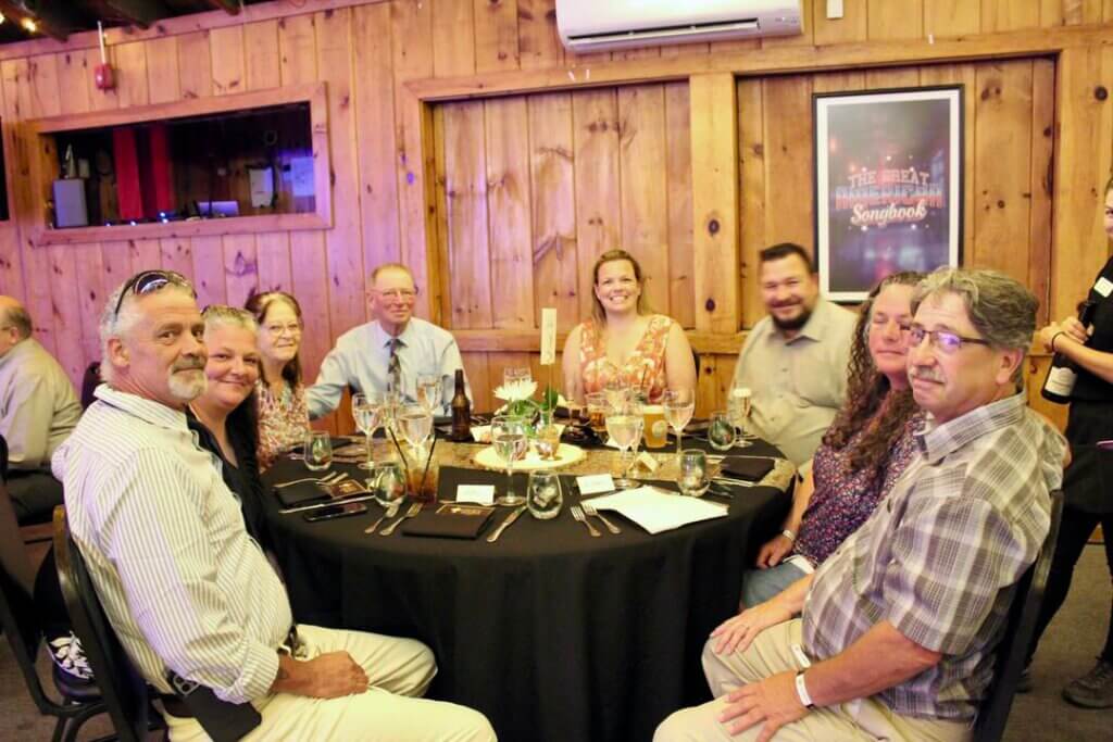 Friends sitting around a table at the Point Sebago Resort Resident&#039;s Choice Awards.