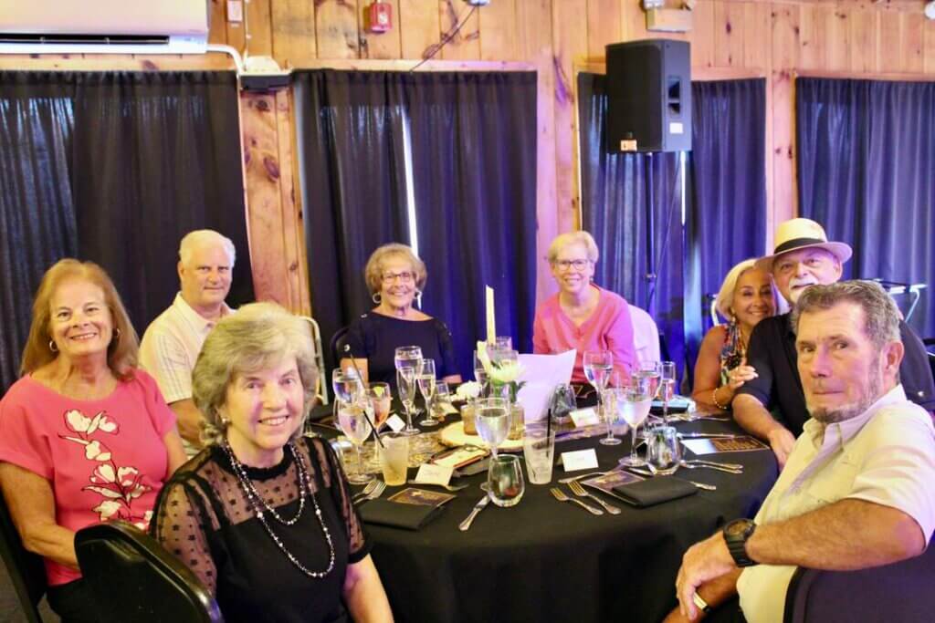 Neighbors sitting around a table at the Point Sebago Resort Resident&#039;s Choice Awards.