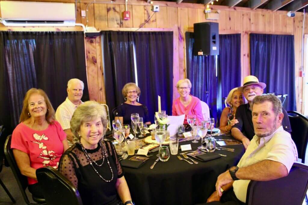 Neighbors sitting around a table at the Point Sebago Resort Resident&#039;s Choice Awards.