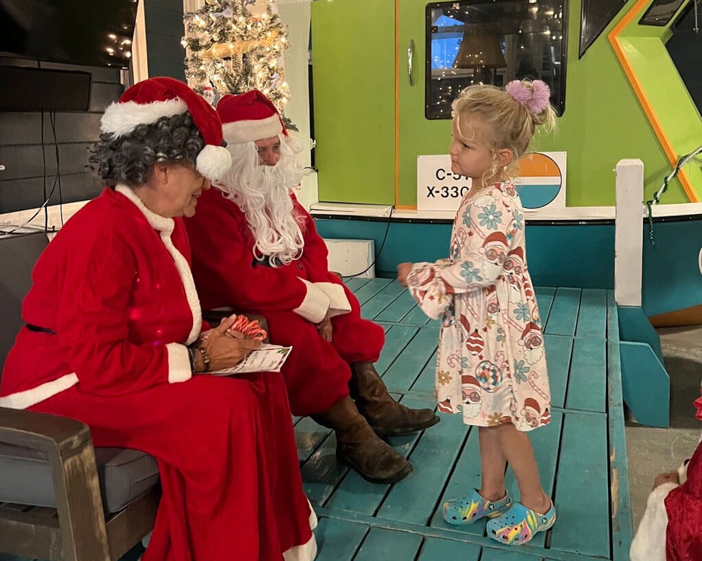 A little girl talking to Santa and Mrs. Claus at Big Pine Key Rv Park in Florida