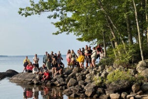 The Caledonia camping crew posing on the rock at Point Sebago Resort in 2025.