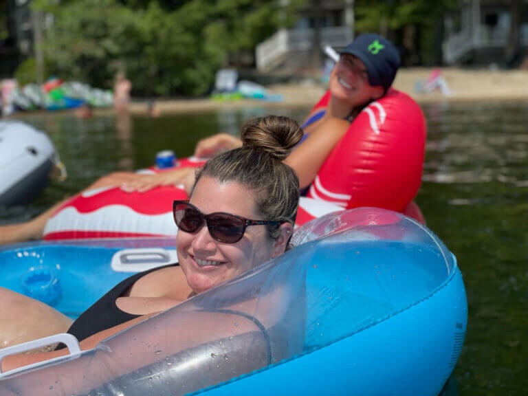 Elizabeth Caledonia floating on Sebago Lake in a tube with a friend.