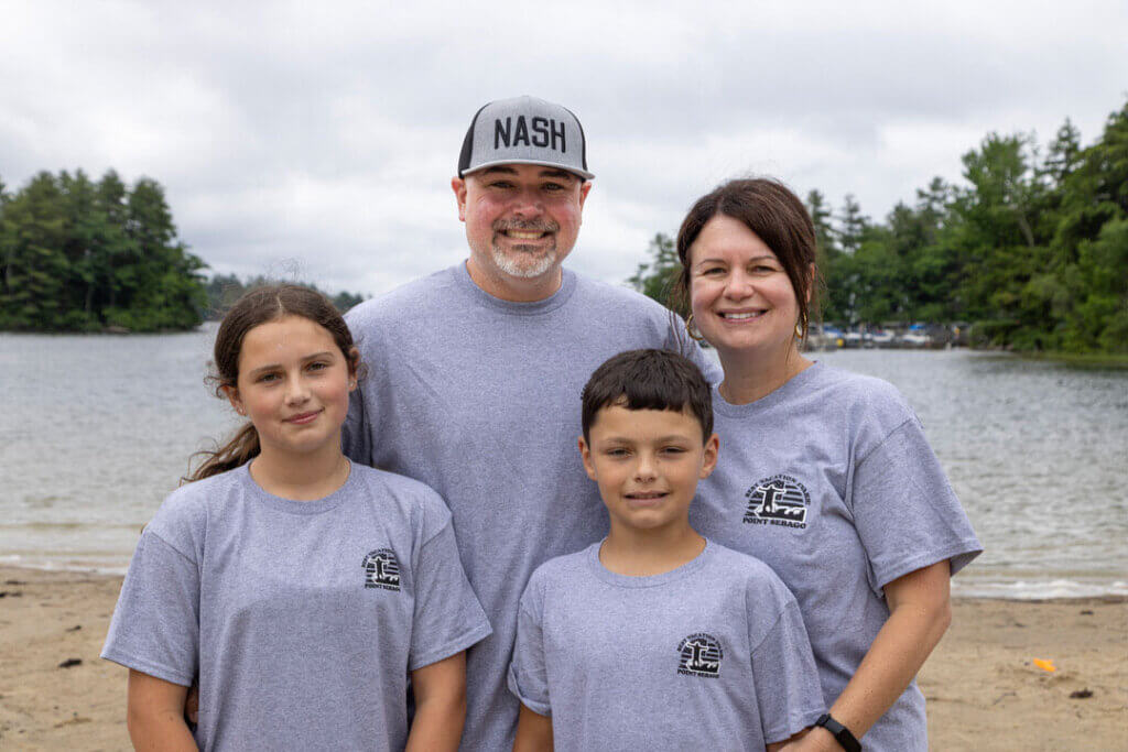 Family posing on the beach at Point Sebago Resort in Casco, Maine.