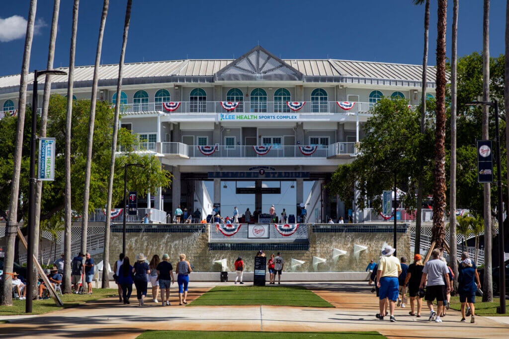 Hammond Stadium at Lee Health Sports Complex, Fort Myers, Lee County, Florida, spring training home of the Minnesota Twins baseball team. Palm trees lining the wide walkway towards the front of the stadium, clear blue sky. Photo taken March 20, 2024 before a Twins spring training game. Photo from iStock.