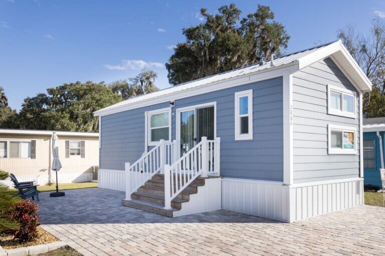 Exterior of a manufactured home (Lot 200G) in Oak Harbor RV Park, located in Haines City, Florida.