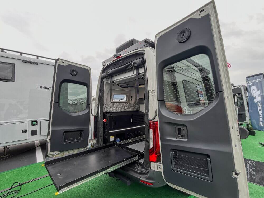 Tiffin Camper Van GH1 03 Rear view of a Tiffin camper van with its back doors open, slide-out tray and interior storage.