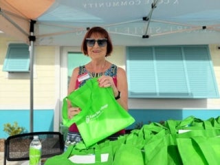 Resident handing out bags at an open house event in Estero Bay Village in Estero, Florida.