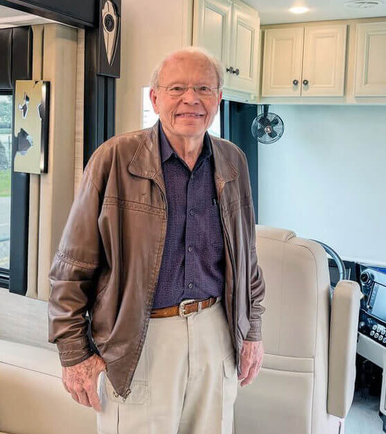 Bob Tiffin, founder of Tiffin Motorhomes, standing in the The Bob Tiffin Limited Edition Allegro Bus.