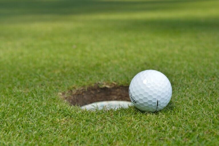 Golf ball rolling into the hole at Point Sebago Resort Golf Course in Maine.