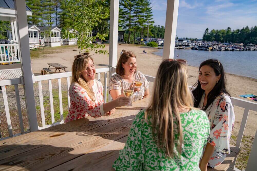 Friend drinking wine at a lakefront cabin on Sebago Lake in Maine.
