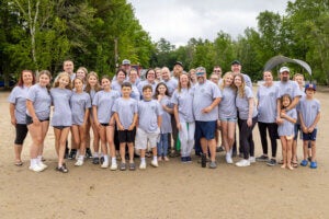 Family posing together on the beach at Point Sebago Resort in Maine.