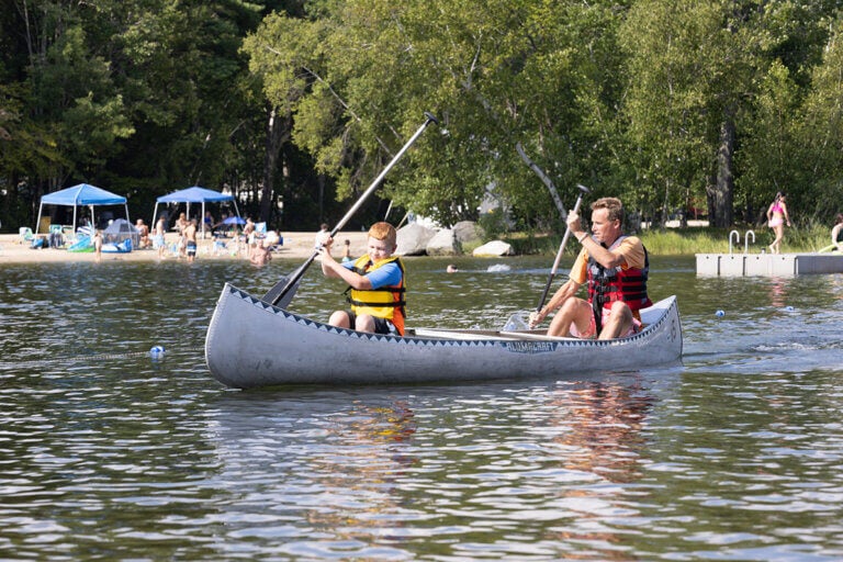 Father and son canoeing on Sebago Lake in Maine.