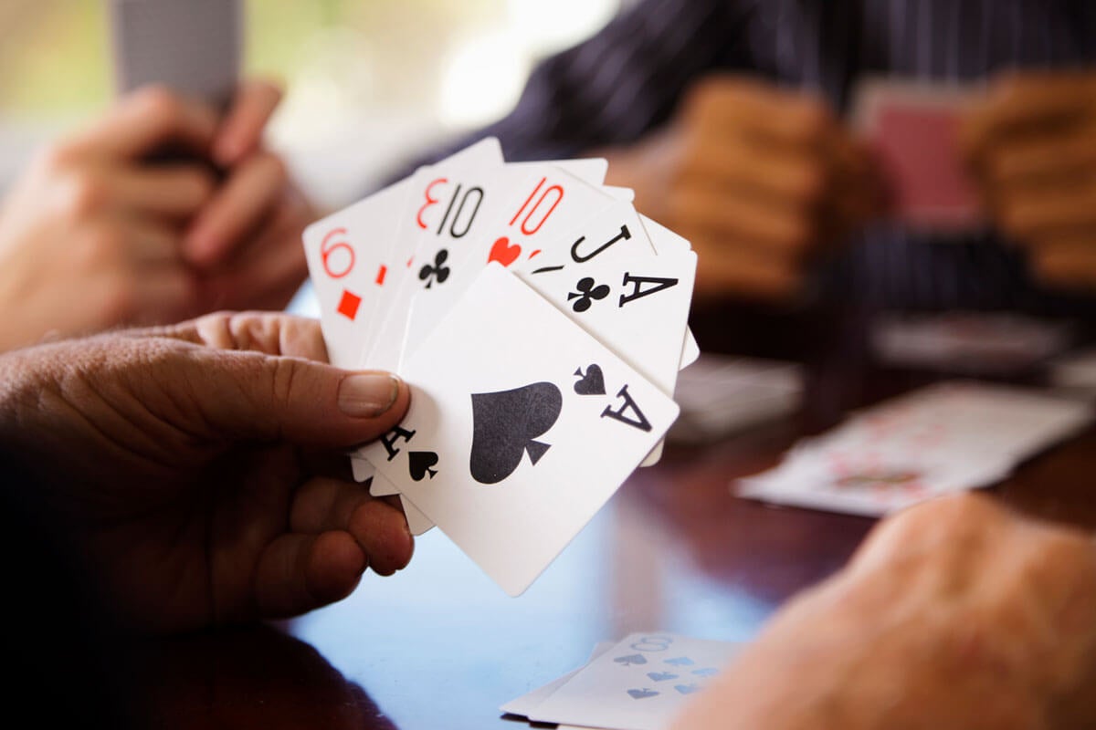 A hand holding cards during a poker game.