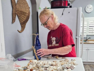 Residents with their decorated blue glass bottle creations from a craft class at Holiday RV Park in Leesburg, FL.