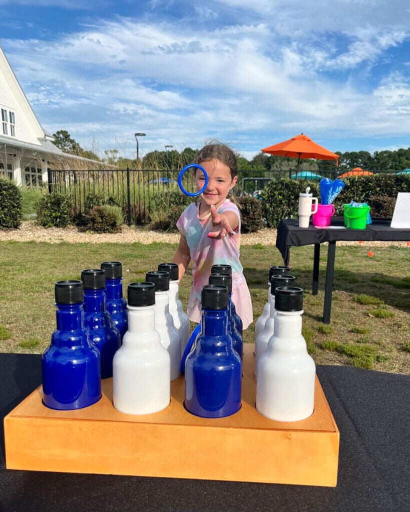 Little girl throwing a ring during a ring toss game at a carnival themed weekend at Creekfire RV Resort in Savannah, Georgia