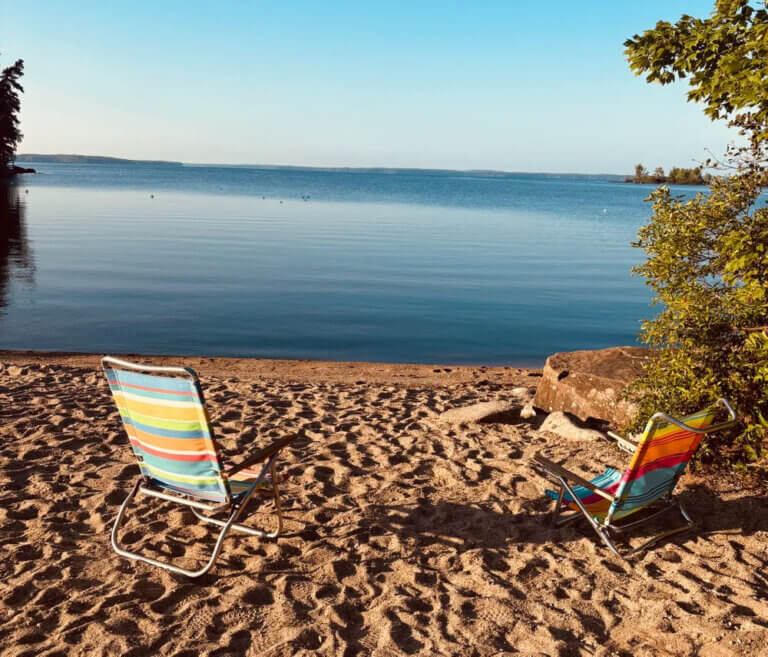 Two beach chairs looking out on Sebago Lake in Maine