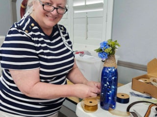 Residents with their decorated blue glass bottle creations from a craft class at Holiday RV Park in Leesburg, FL.