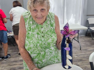 Residents with their decorated blue glass bottle creations from a craft class at Holiday RV Park in Leesburg, FL.