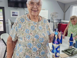 Residents with their decorated blue glass bottle creations from a craft class at Holiday RV Park in Leesburg, FL.