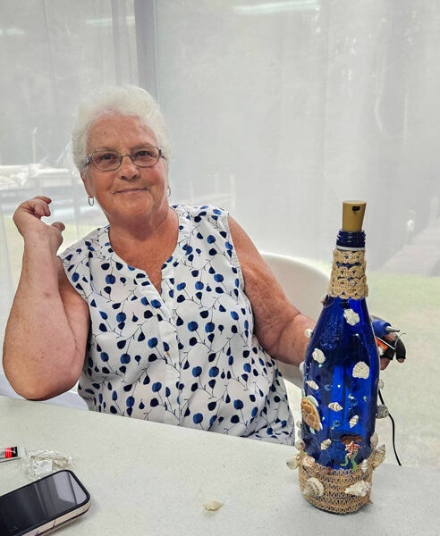 Residents with their decorated blue glass bottle creations from a craft class at Holiday RV Park in Leesburg, FL.