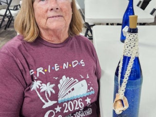 Residents with their decorated blue glass bottle creations from a craft class at Holiday RV Park in Leesburg, FL.