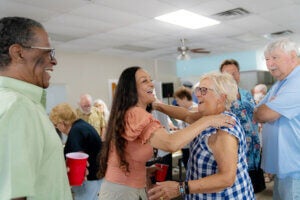 Women hugging at an RV resort potluck at River Vista RV Park.