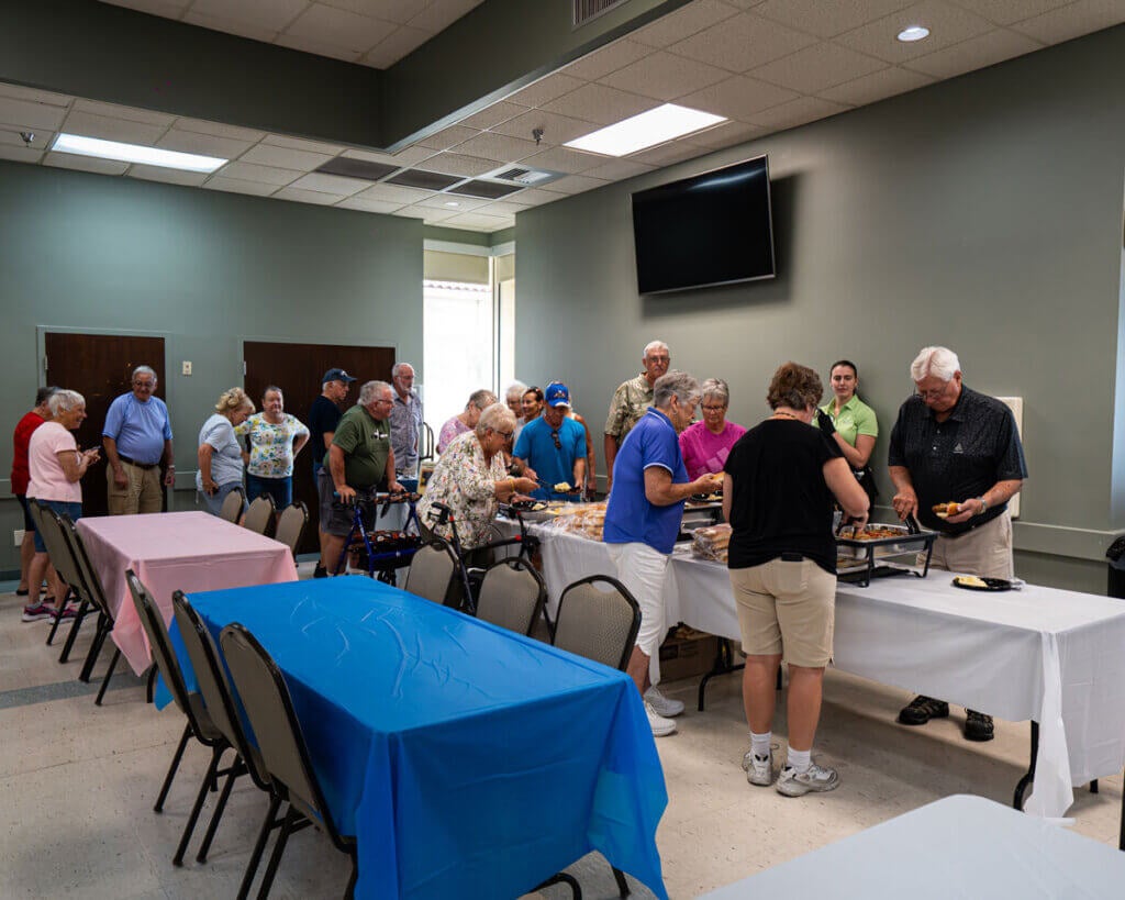 55+ residents in the buffet line at the Resident Picnic in Cypress Lakes Village in Lakeland, Florida.