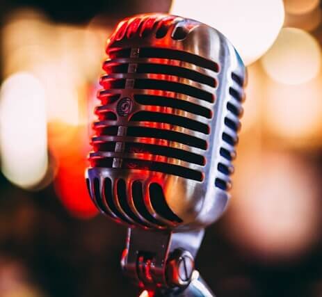 Photo of a retro microphone in front of variety color lights