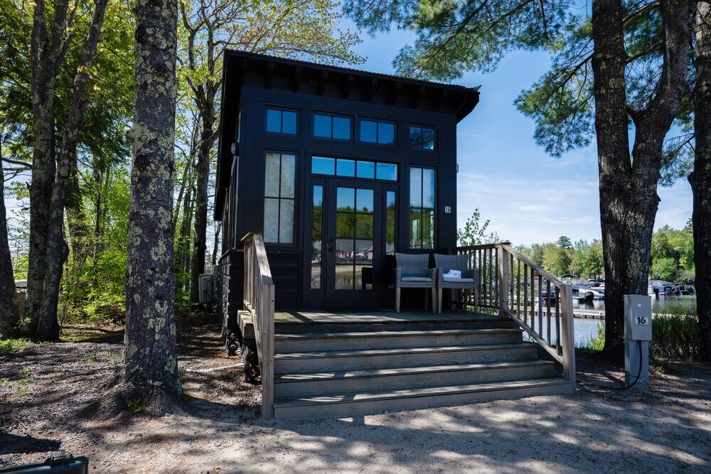 Exterior of the Saltbox Cabin rental at Point Sebago Resort in Maine with Sebago Lake in the background.