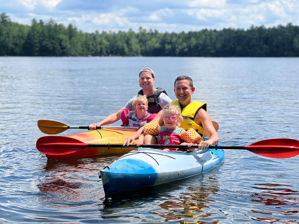 sebago-lake-kayak-kids Two men kayaking with kids on Sebago Lake in Maine.