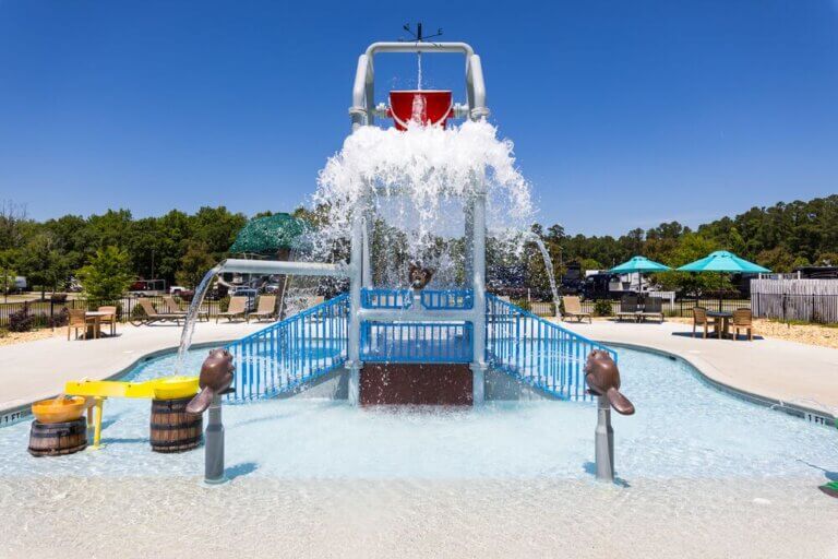 Splash pad bucket dropping water at CreekFire RV Resort in Savannah, Georgia.