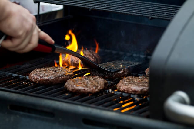 Burgers being cooked on a grill.