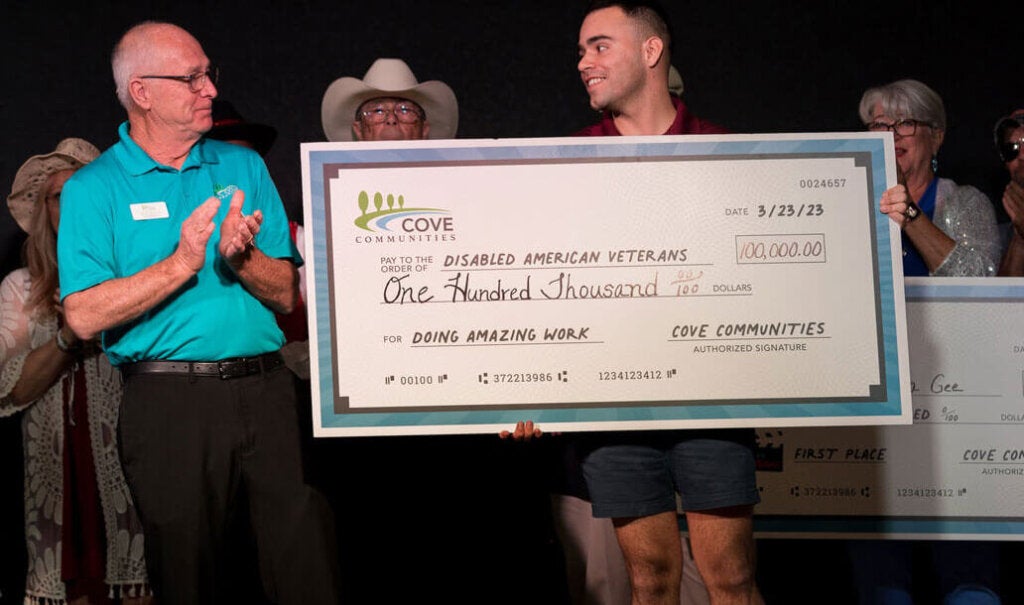 Greg Barton handing check to DAV representative at Cove's Got Talent