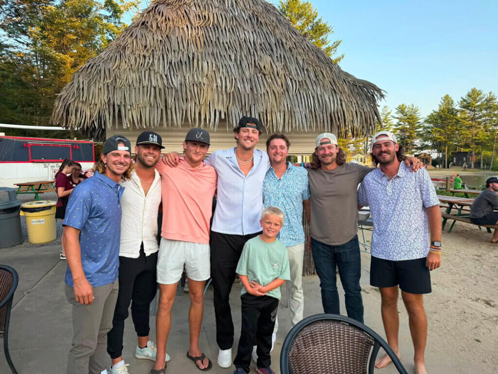 Players from the Texas Tailgaters posing with a fan at Point Sebago Resort in Maine.