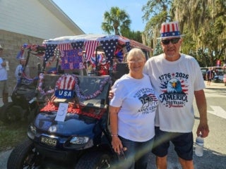 Residents with a decorated golf cart for the 4th of July parade at Holiday RV Park in Leesburg, Florida.
