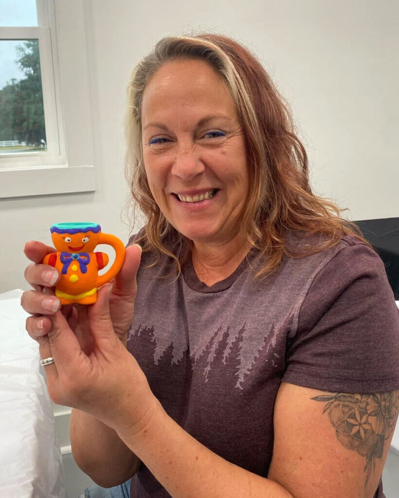 Guest at CreekFire RV Resort in Savannah, Georgia holding a gingerbread cup