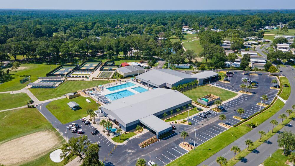 Pickleball courts, shuffleboard courts, bocce ball, and the aquatic center all surrounding the Rolling Greens Village clubhouse in Ocala, Florida.