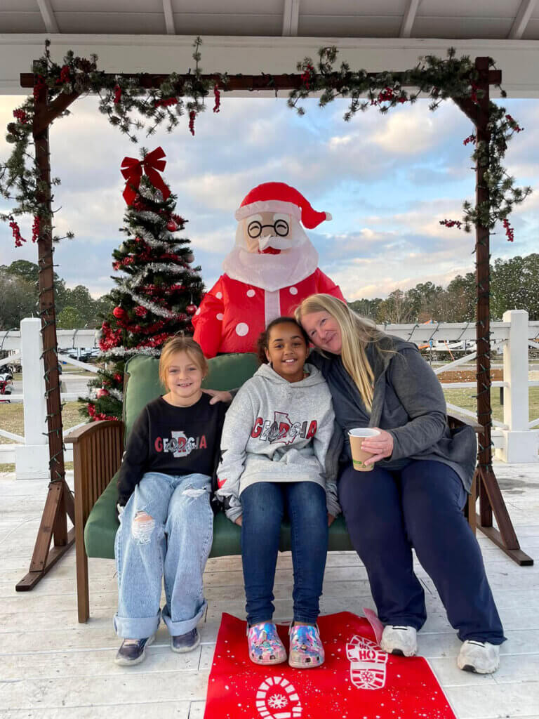 Guests sitting on bench with holiday decorations at CreekFire RV Resort in Savannah, Georgia