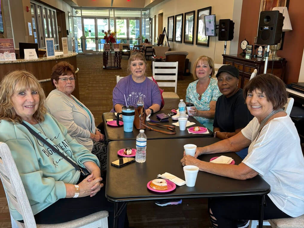 Denise posing with friends around the table at the Rolling Greens Village Clubhouse in Ocala, Florida.